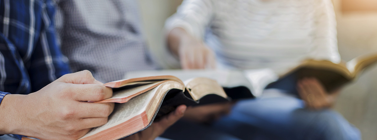 Christian friends group reading and study bible together in home